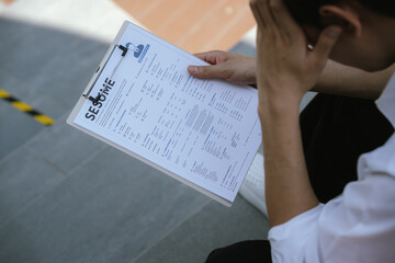 Naklejka premium Job applicant reviewing a resume document before an interview, reflecting career planning, employment opportunities, job search preparation, and professional development.