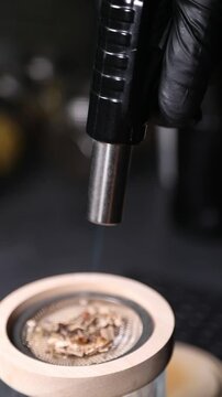 Barman encendiendo un ahumador de vidrio con soplete para un c&oacute;ctel. Barman profesional encendiendo un ahumador de virutas de madera con soplete. C&oacute;ctel ahumado, t&eacute;cnica de bar vanguardista.
