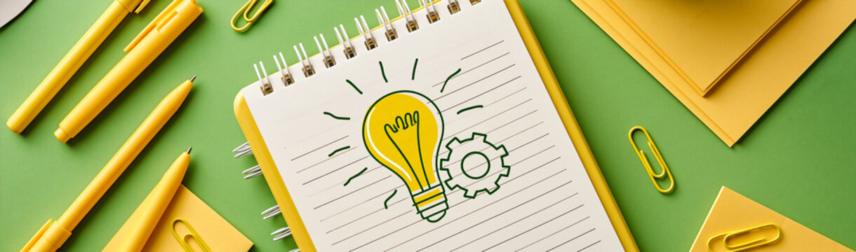 Idea Generation Process: A spiral notebook displays a bright lightbulb illustration alongside a gear, symbolizing innovation and problem-solving.