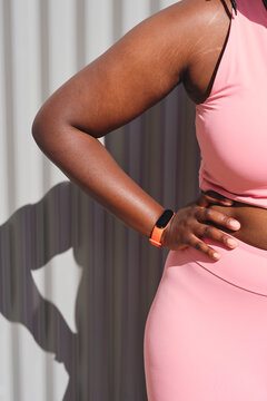 Woman with hand on hip in front of wall