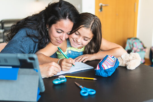 Mother homeschooling daughter at home