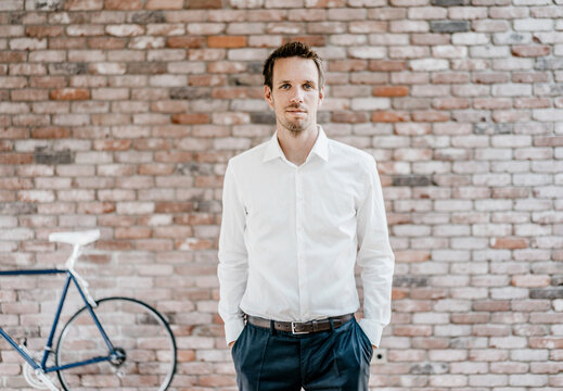 Portrait of confident businessman in front of brick wall