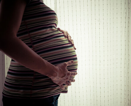 Pregnant woman against bright window