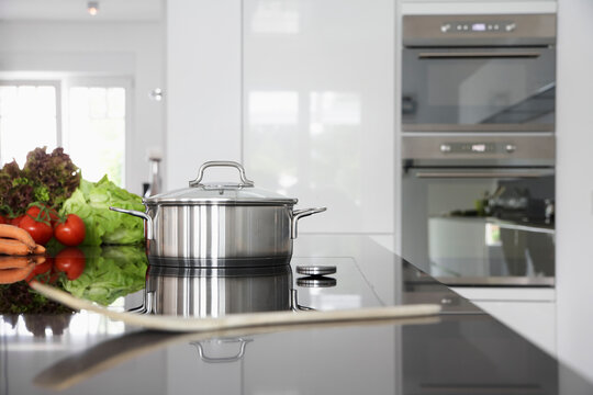 Germany, Cologne, Pot and vegetables on kitchen surface
