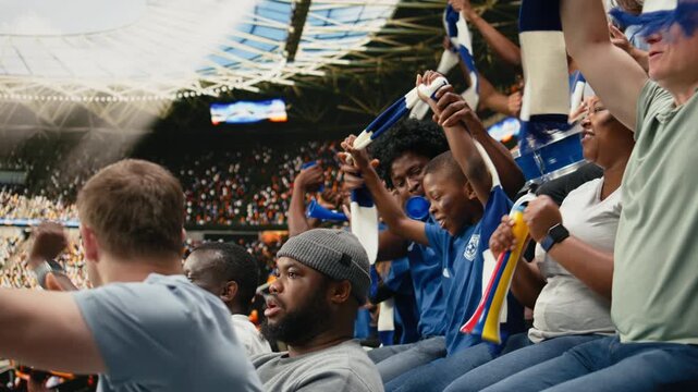 Black father with vuvuzela spending quality time with son at soccer stadium full of cheering fans, football lifestyle, parenthood and family bonding, blue team support and childhood joy.