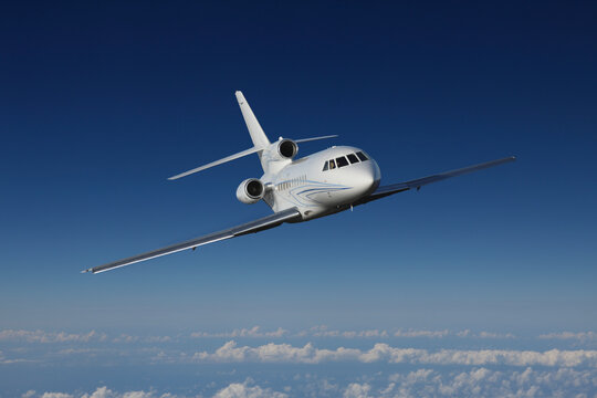 Germany, Bavaria, Munich, Businessjet falcon 900 flying in blue sky
