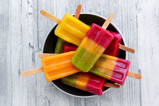 Bowl of various homemade fruit smoothie ice lollies
