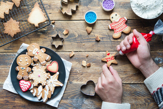 Man's hand decorating Christmas cookie