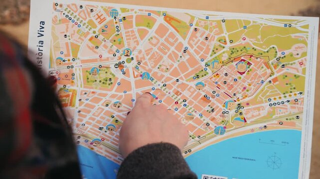 A tourist with a paper map points out landmarks with finger. Travel concept. High quality 4k footage