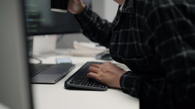 Close-up of hands typing on a computer keyboard, working on network server security and personal cyber data privacy system at a desk in a modern office.