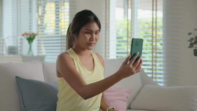 Asia people young adult woman using digital device screen phone scan age app look at camera smart bioage face online test agentic AI. Asian female Health care facial skin anti aging beauty tracker.