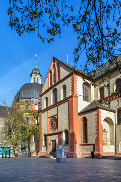 Neumunster church courtyard view in Wurzburg, Germany. Low angle perspective of the historic building under a blue sky