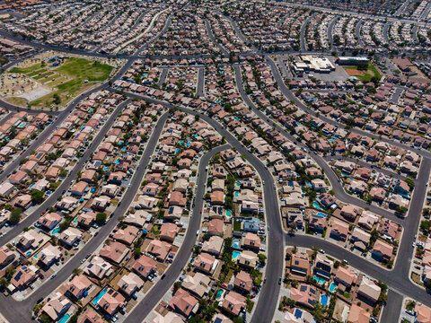 High angle aerial shot of a dense suburban housing development with curved streets