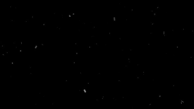 Slow motion heavy white dust particles and debris elements falling against a dark black background motion effect