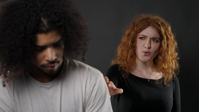 Upset woman arguing with a man turning away showing conflict emotions