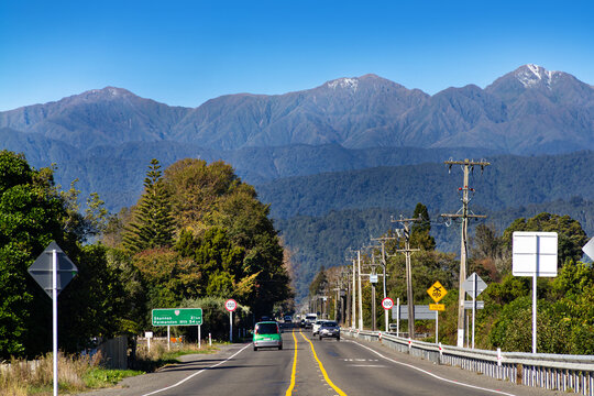 New Zealand. State Highway 57 beneath Northern Tararua Range with light snow. Mountains L-R: Pukemoremore, Mt Logan, Mt Dundas. Classic New Zealand rural infrastructure of power lines and road signs.