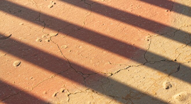 Cracked Earth Texture with Diagonal Sunlight Stripes