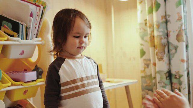 Cute 3 year old girl sculpting modeling clay and giving it to mother at cozy family home authentic playful childhood lifestyle moment indoors slow motion 4K