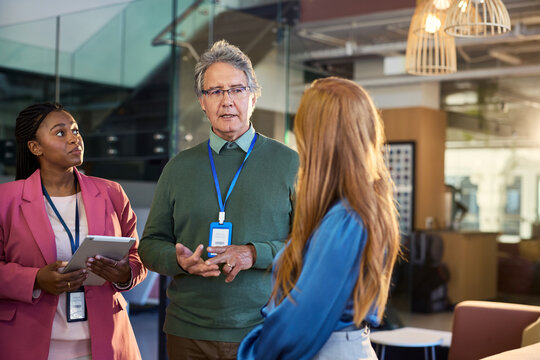 Mature businessman discussing during annual meeting with multiethnic colleague