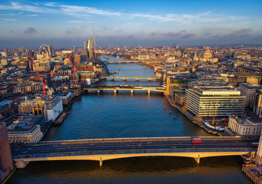 Panoramic aerial view of London Bridge until back to St. Pauls Cathedral and Waterloo Bridge during a golden sunrise