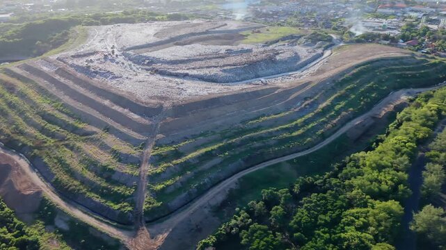 Aerial view of TPA Suwung landfill with terraced waste management system in Bali