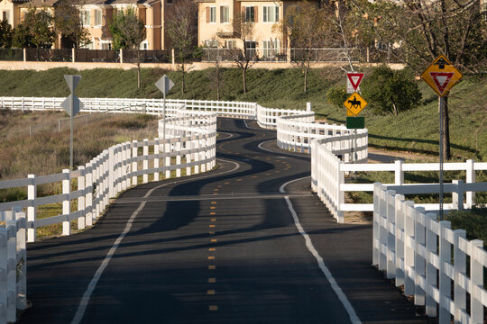 Suburban bike path with white fencing along the San Francisquito Creek Trail in Santa Clarita California.