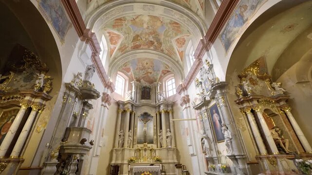 Vilnius, Lithuania &ndash; June 10,2026: Wide sliding view inside of The Church of the Holy Cross showcasing ornate ceiling frescoes and altar