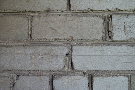 Texture of old and weathered grey brick wall
