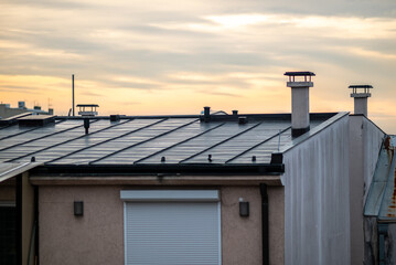 Fototapeta premium Modern house rooftop with chimneys at sunset