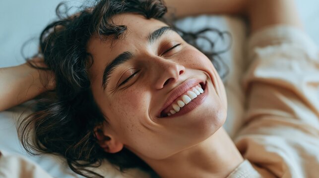 Close-up of a joyful woman with eyes closed, smiling broadly with her head tilted back