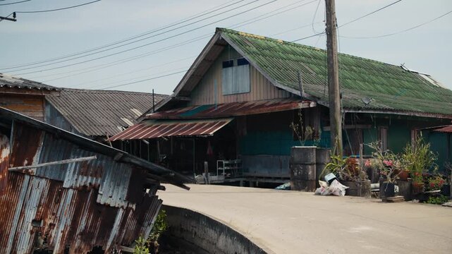 Man riding a sidecar motorcycle in a poor thai village
