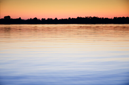 Calm Black Lake reflecting sky at sunset