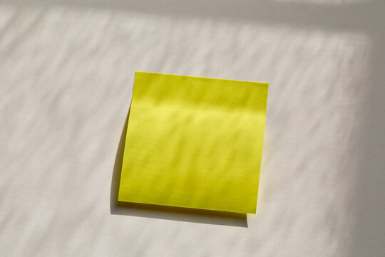 Blank yellow post it note on wall