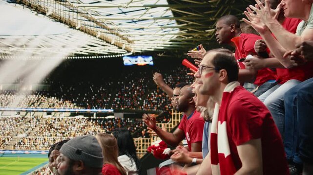 Tense soccer fans watching decisive moment during live football match in stadium filled with suspense and anticipation, worried fans holding breath during crucial penalty kick, serious crowd.
