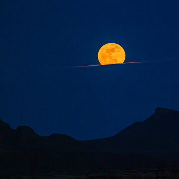 Pink Moon rising over cloud bank