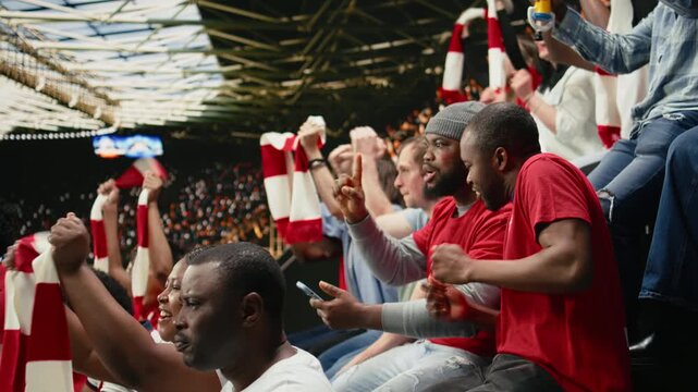 Shocked supporter celebrating high stakes betting win on mobile betting app during a live soccer match inside the stadium.