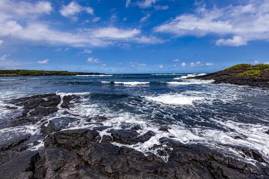Motion blurred ocean waves washing coastal rocks