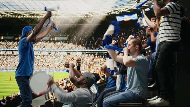 Energetic supporters beating percussion drum and blowing vuvuzelas, crowd leader uniting fans with megaphone in blue fan section.