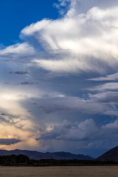 Dramatic clouds over mountains and field