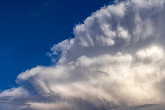 Dramatic white clouds in sunlight on blue sky