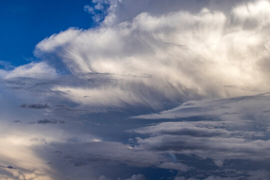 Dramatic white clouds in sunlight on blue sky