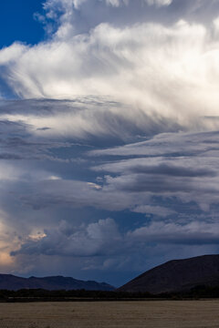 Dramatic clouds over mountains and field