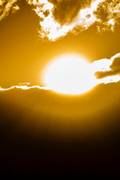 Golden sun setting behind clouds