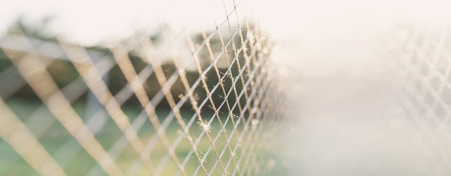 Close-up of a soccer goal net against a sunny,  defocused summer background bunner copy space