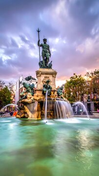 Statue of a man with cross standing on fountain.