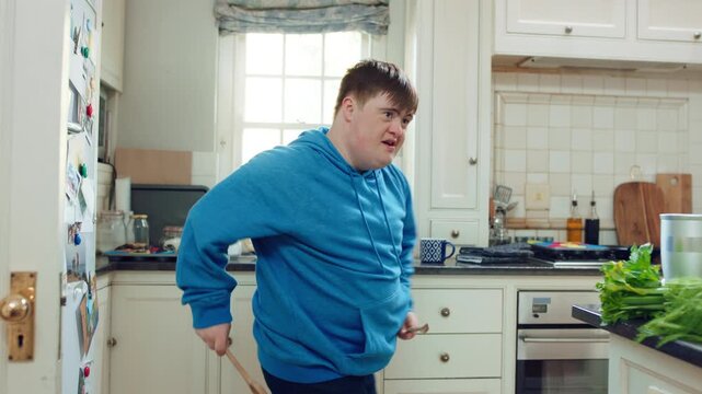 Kitchen, dance and teen with spoon, rhythm and performance for cooking success or moving with energy. Dancer, active and person with down syndrome, juggle and celebration for culinary skills in house