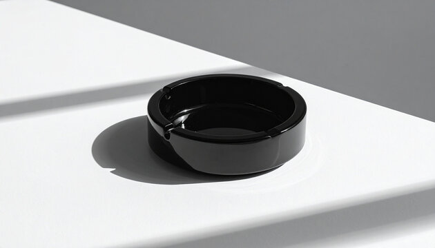 Black ashtray on white surface
