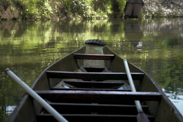 Naklejka premium A wooden boat on a greenish river