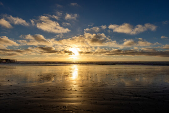 Sun setting over beach and calm ocean