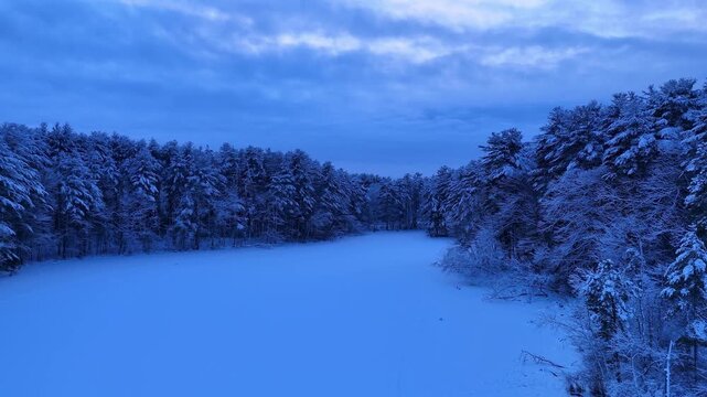 Drone flying on a frozen lake during winter, stunning dramatic aerial view, Harold Parker State Forest, Massachusetts